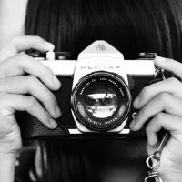 A person holding a camera to their eye. 