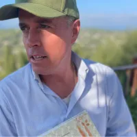 Photo of author holding book. 