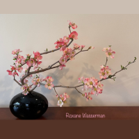 an Ikebana floral arrangement - black vase, pick flowers on branches